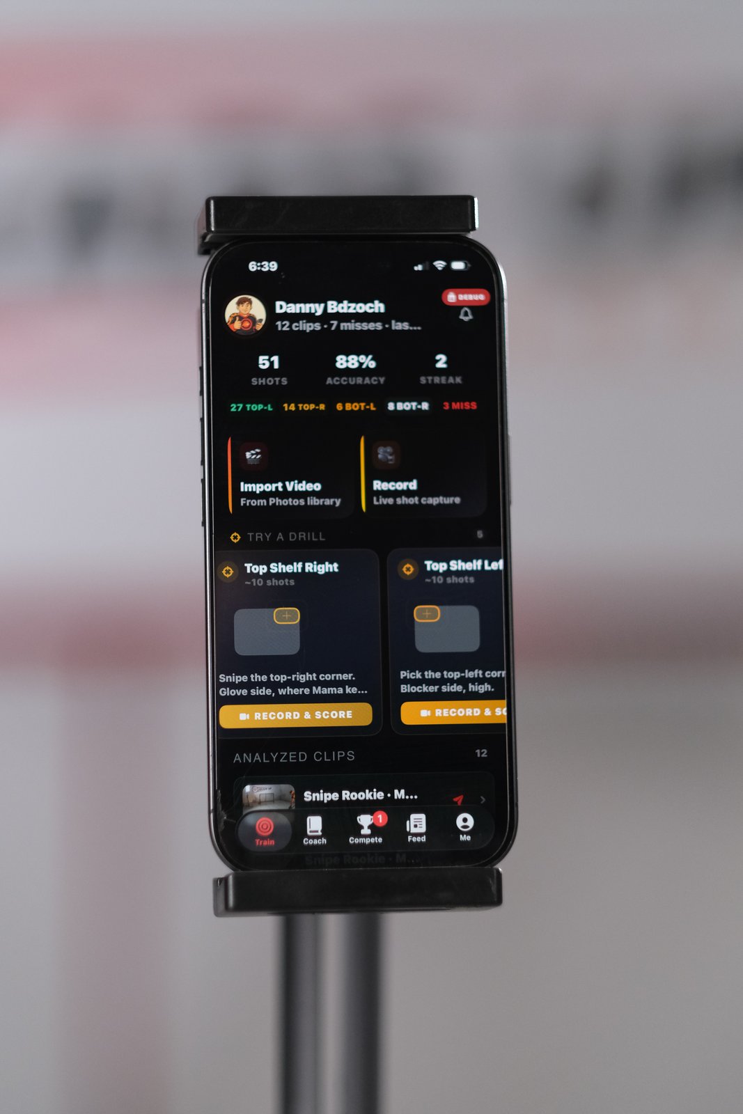 Phone running the Heads Up Shooting app on a tracking stand in front of a hockey net